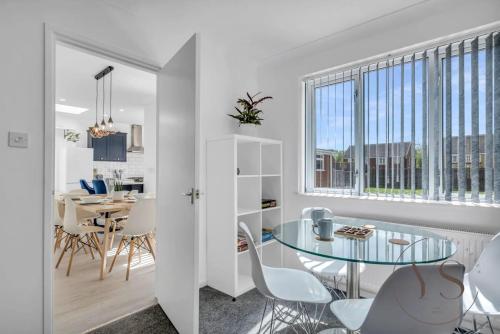 a kitchen and dining room with a glass table and chairs at Modern 3BR Home in 9 Anson Rd Near Sandwell Hospital with Garden and Free Parking in West Bromwich