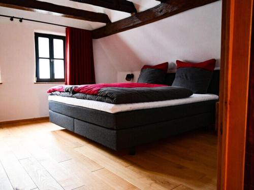 Un dormitorio con una cama con almohadas rojas. en Holiday home time out in the monument en Lohr