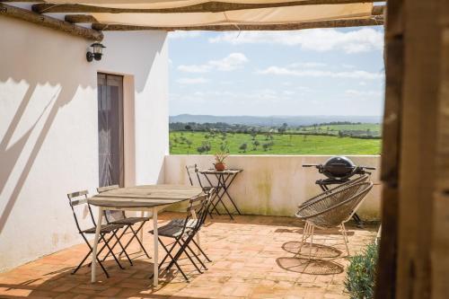 un patio con mesa, sillas y parrilla en Costa Vicentina cottage with a view, en Cercal