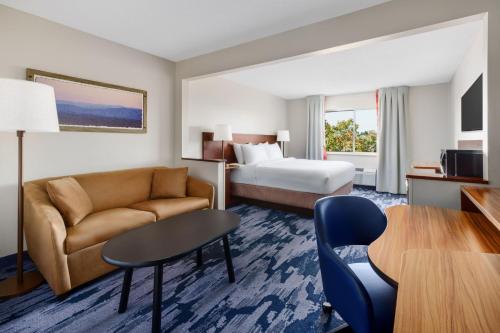 a hotel room with a bed and a couch and a table at Fairfield Inn Philadelphia Airport in Philadelphia