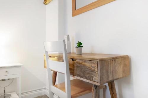 a desk with a chair next to a desk with a plant on it at Stylish Comfort, Near Auckland Castle, Sleeps 4 in Crook