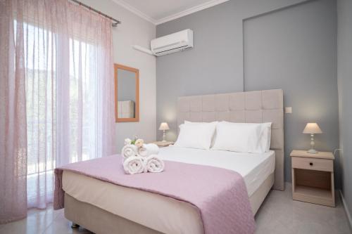 een slaapkamer met een groot bed en 2 handdoeken bij Famozo Hill Private Villa in Káto Yerakaríon