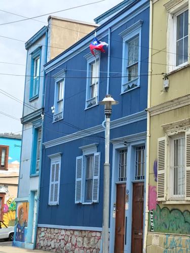 a blue building with a red flag on it at B&B La Nona in Valparaíso