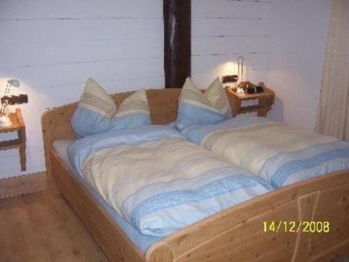 - un lit en bois avec des oreillers dans l'établissement Wohnung Haus Sport Alpin Nr 10 mit Terrasse in Oberstdorf-Tiefenbach, à Oberstdorf