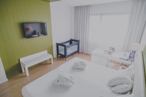 a bedroom with two beds and a tv on the wall at Hotel Zentral Castellana Norte in Madrid