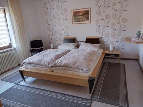 a large bed in a bedroom with two tables at Ferienwohnung Hilla in Taben-Rodt