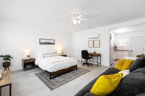 een witte slaapkamer met een bed en een bank bij Lovely Studio in the Heart of Victoria Park in Fort Lauderdale