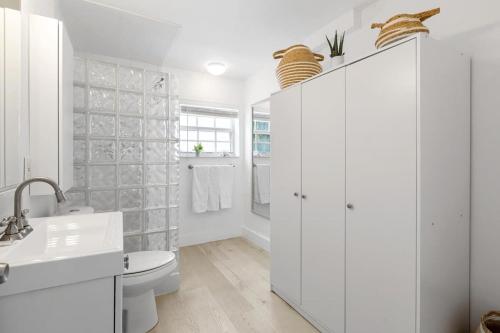een witte badkamer met een toilet en een wastafel bij Lovely Studio in the Heart of Victoria Park in Fort Lauderdale