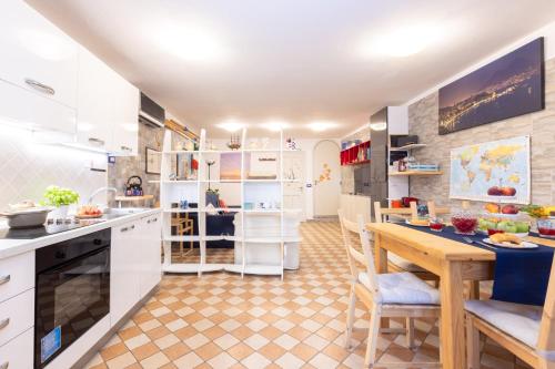 een keuken met witte kasten en een tafel en stoelen bij Marinautica Sea Cottage in Sorrento