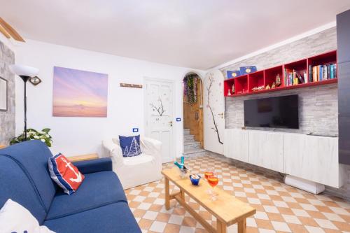 a living room with a blue couch and a table at Marinautica Sea Cottage in Sorrento