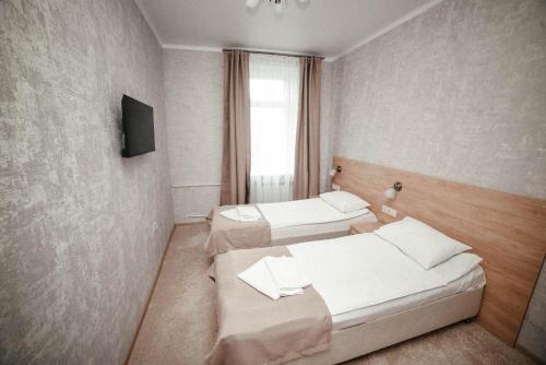 een hotelkamer met 2 bedden en een televisie bij Mini Hotel on Saydasheva in Kazan
