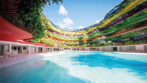 a large swimming pool with plants on the side of a building at LHV Luxury Apartment Boas in Ibiza Town
