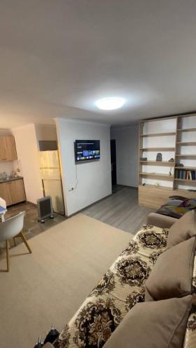 ein Wohnzimmer mit einem Sofa und einem TV an der Wand in der Unterkunft Квартира in Priozersk