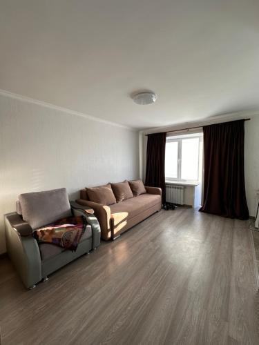 ein Wohnzimmer mit einem Sofa und einem Fenster in der Unterkunft Квартира in Priozersk