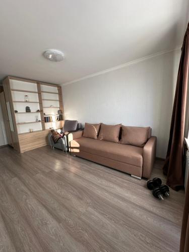 ein Wohnzimmer mit einem braunen Sofa in einem Zimmer in der Unterkunft Квартира in Priozersk