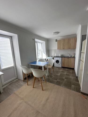 ein Wohnzimmer mit einem Tisch und Stühlen sowie eine Küche in der Unterkunft Квартира in Priozersk