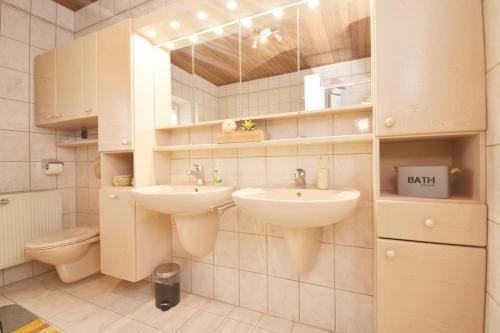 a bathroom with two sinks and a toilet at GUN04-FW Apartment in Windsbach in Windsbach