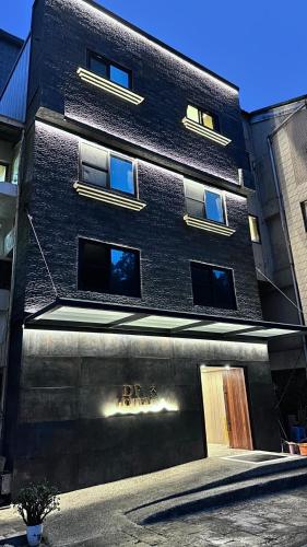 a black building with a sign on the side of it at Dafong Hotel in Zhongzheng