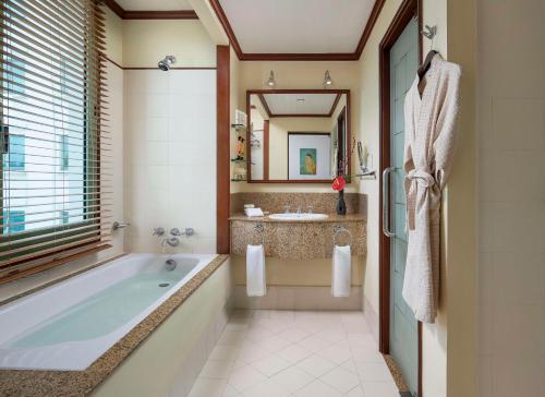 a bathroom with a tub and a sink at Avani Hai Phong Harbour View Hotel in Hai Phong