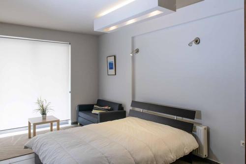 a bedroom with a bed and a chair and a window at Luxury Flat Cosy Bright in Gazi Kerameikos Metro in Athens