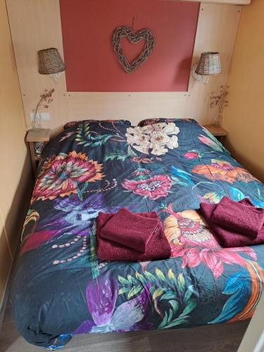 a bed with a colorful comforter in a room at Vakantie bij 17 in Serooskerke