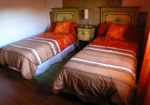 um quarto com 2 camas com lençóis laranja em Villa rural en urbanización próxima a Ávila by Alterhome em Peñalba de Ávila