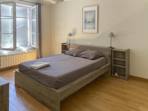 une chambre avec un grand lit avec deux serviettes dessus dans l'établissement Le Jardin des Chenes, à Eyragues