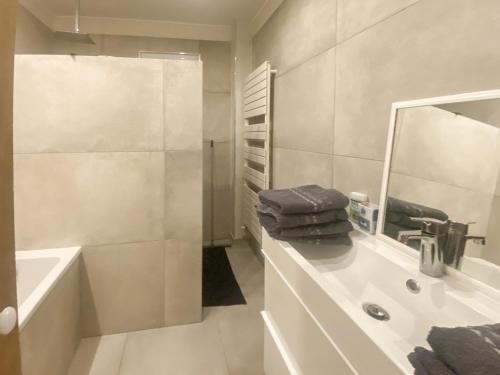 une salle de bain blanche avec un lavabo et un miroir dans l'établissement Le Jardin des Chenes, à Eyragues