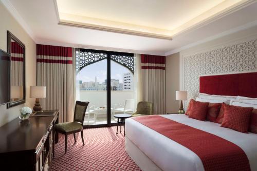 a hotel room with a bed and a large window at Al Najada Doha Hotel by Tivoli in Doha