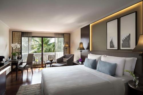バンコクにあるアナンタラ・リバーサイド・バンコク・リゾートのベッドルーム(大型ベッド1台付)、リビングルームが備わります。