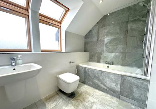 a bathroom with a toilet and a tub and a sink at St Cadoc in Padstow