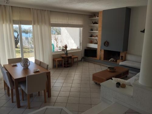 sala de estar con mesa y comedor en V.K.Seaside Villa, en Volos