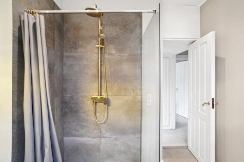 y baño con ducha y cortina de ducha. en Luksuriøst 3BR Strandhus m.plads til 6 personer, en Hellerup