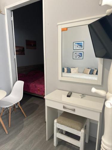 1 dormitorio con escritorio blanco y espejo en BYZANTIUM APARTMENTS, en Ermoupoli