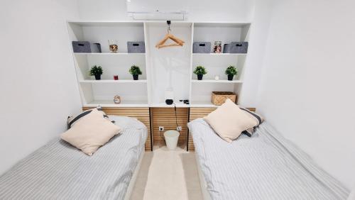 two beds in a room with white walls at Your dream Getaway Awaits in Vale do Lobo in Almancil