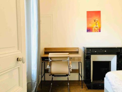 Cette chambre comprend un bureau et une chaise. dans l'établissement Charmant appartement entier à Montmartre pour 4, à Paris