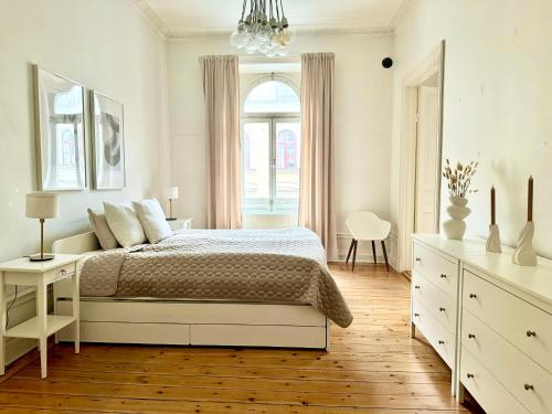 a white bedroom with a bed and a window at Lägenhet med fantastiskt läge in Stockholm