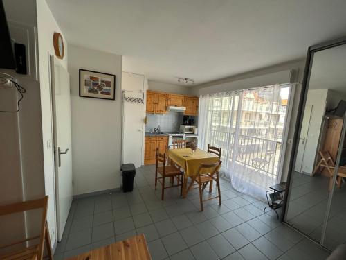 une cuisine et une salle à manger avec une table et des chaises dans l'établissement la rafale, à Fort-Mahon-Plage