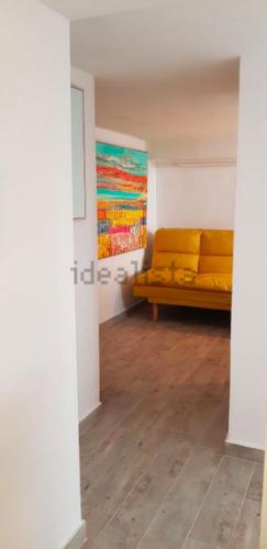 a living room with a yellow couch in a room at Barrio Andaluz apartment in Almuñécar