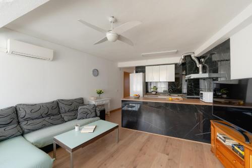 un soggiorno con divano e una cucina di Apartamento villa playa a Benidorm