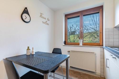 a kitchen with a table and a clock on the wall at Fewo Schwarzwald - Haus Sommerberg in Baiersbronn