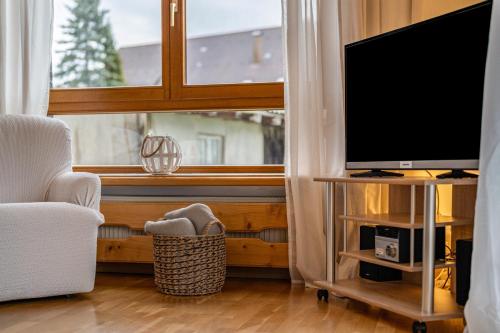 a living room with a television and a window at Fewo Schwarzwald - Haus Sommerberg in Baiersbronn