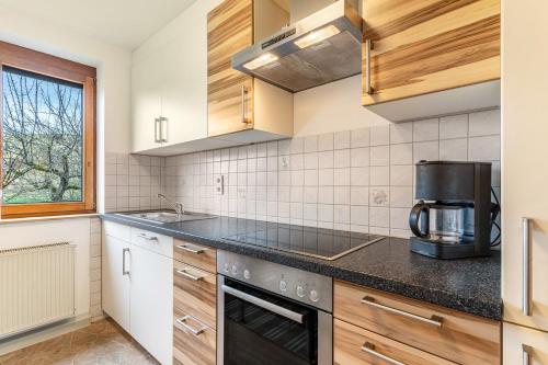 a kitchen with wooden cabinets and a black counter top at Fewo Schwarzwald - Haus Sommerberg in Baiersbronn
