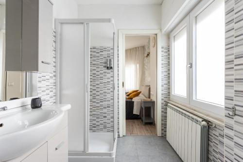 ein weißes Bad mit einer Dusche und einem Waschbecken in der Unterkunft Appartamento in Cagliari