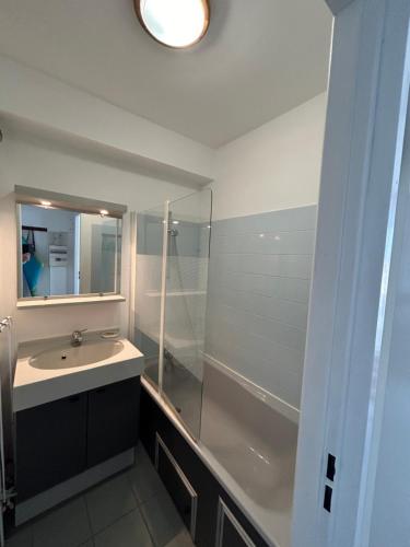 un baño con lavabo y ducha en la rafale, en Fort-Mahon-Plage