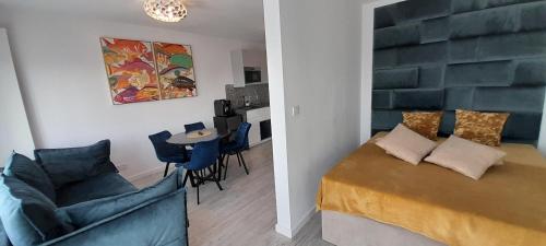 a bedroom with a bed and a couch and a table at Gardenia Seaside Apartament 34 in Dziwnów