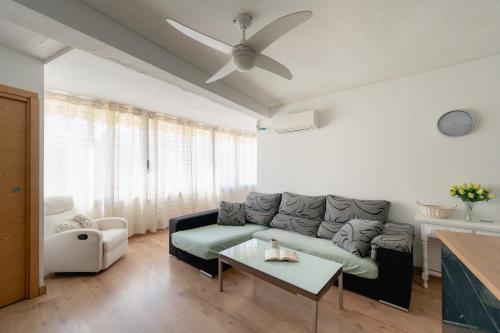 un soggiorno con divano e ventilatore a soffitto di Apartamento villa playa a Benidorm
