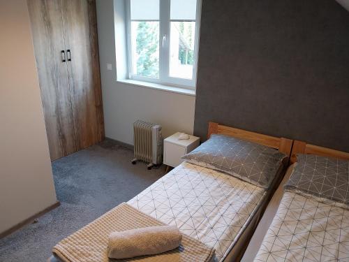 1 dormitorio con 2 camas y ventana en Domek Chmiel II nad Jeziorem Tarnobrzeskim en Chmielów