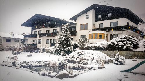 a snow covered yard in front of a house at Haus Brandeck in Uttendorf