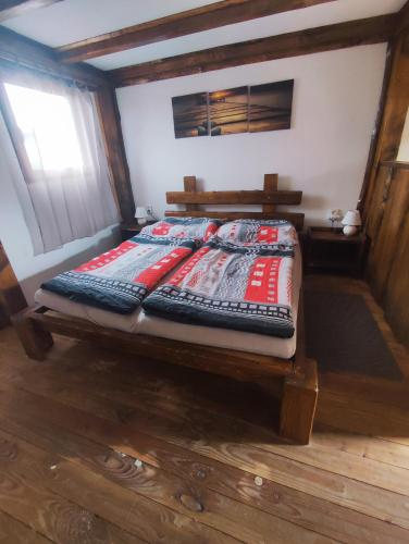 a bed in a room with a wooden floor at Ubytování v komfortní chatce Štít in Chlumec nad Cidlinou